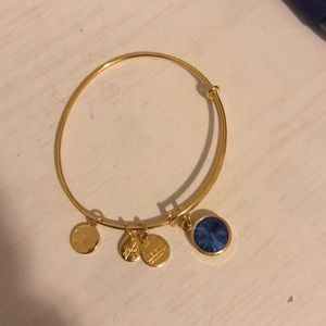 Gold Alex & Ani bracelet with blue sapphire stone
